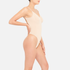 modelo de costado con bodysuit de espalda baja color nude