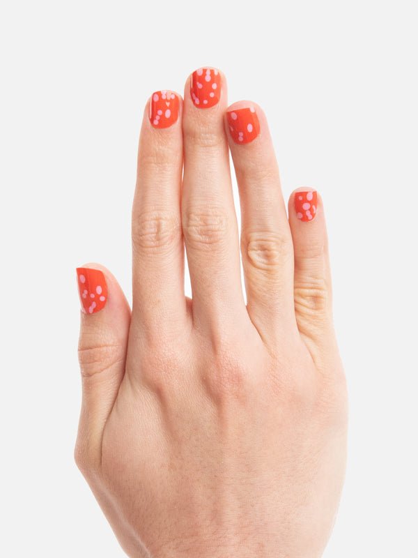 Mano con el esmalte en el tono Polka Dots - ellaz